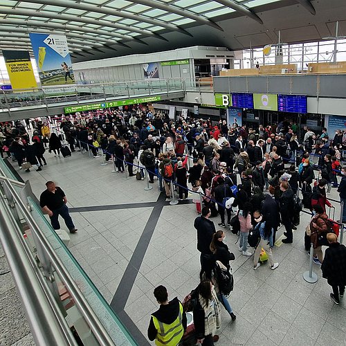 Blick auf viele Menschen in einer Schlange vor einer Sicherheitskontrollstelle am Dortmund Airport