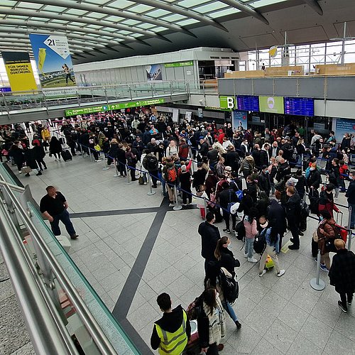 Blick auf viele Menschen in einer Schlange vor einer Sicherheitskontrollstelle am Dortmund Airport